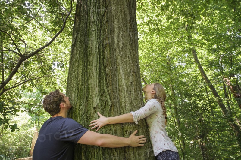 Couple hugging tree.