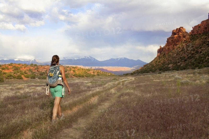 Woman with backpack walking in grass