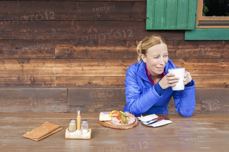 Austria, Salzburger Land, Maria Alm, Mature woman drinking coffee at wooden table