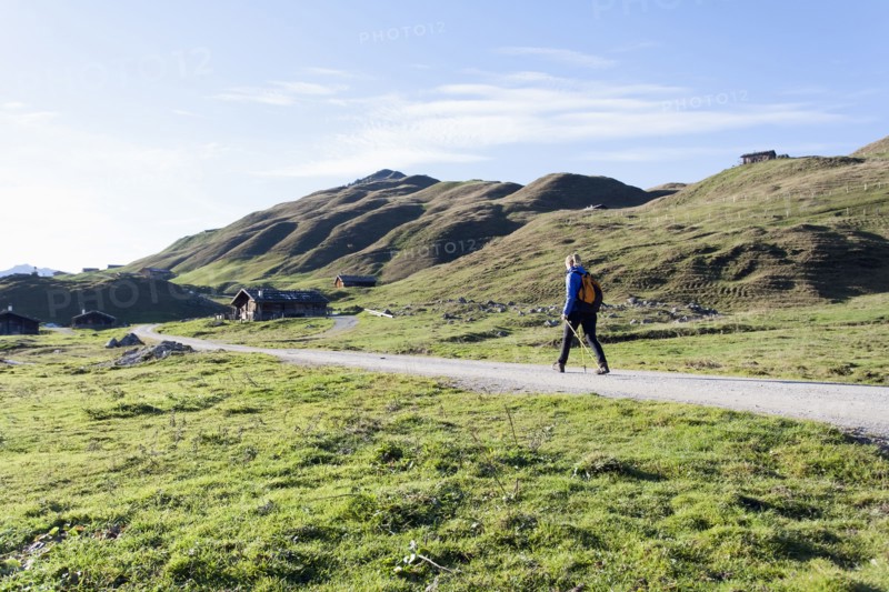 Austria, Salzburger Land, Weissbach, Mature woman hiking on sunny day in mountain landscape