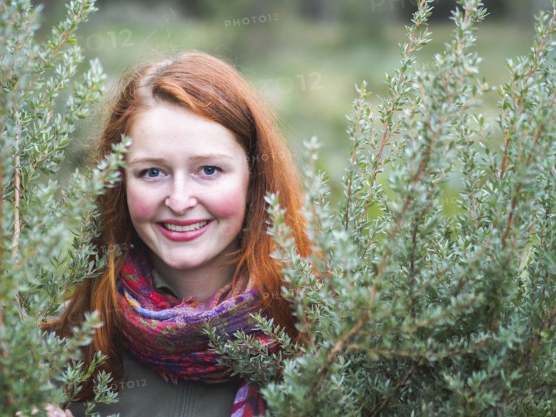 Portrait of smiling redhead in bushes