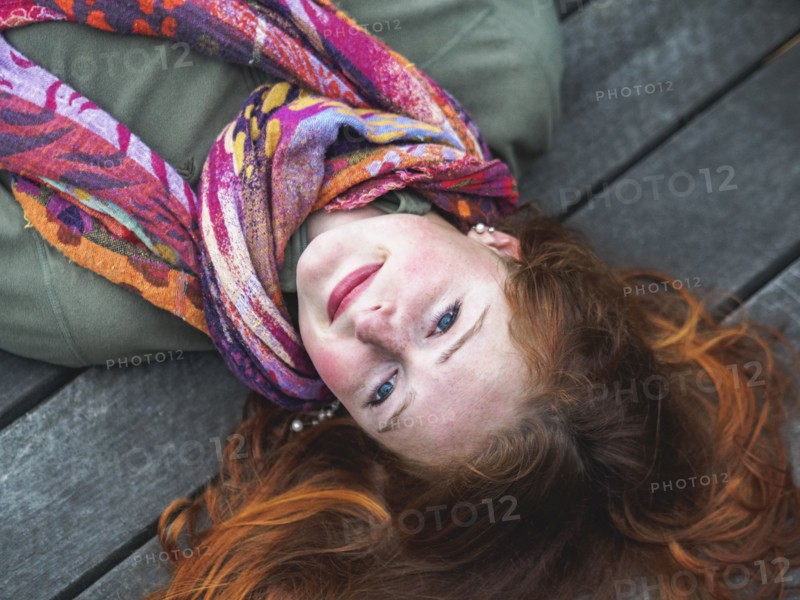 Portrait of smiling redhead lying down