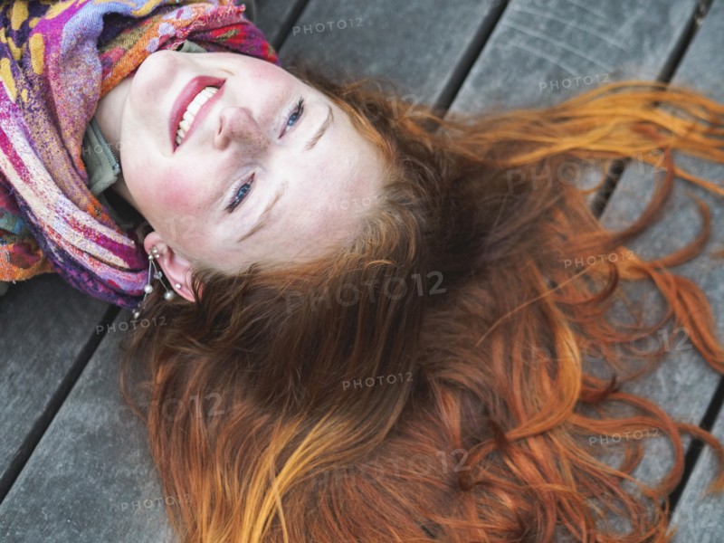 Portrait of smiling redhead lying down