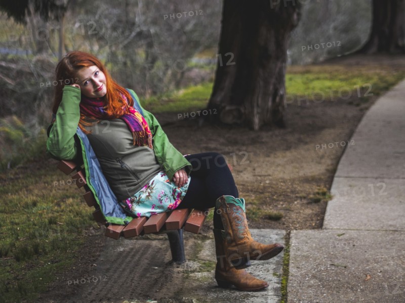 Young woman sitting on bench in park