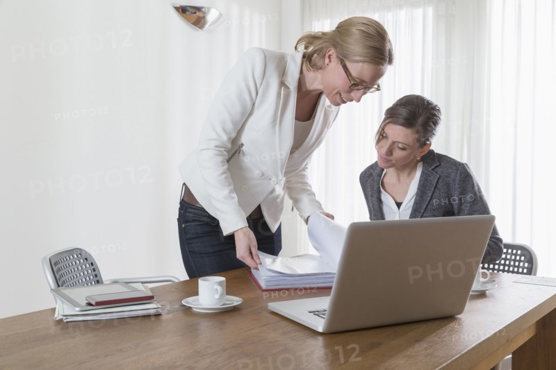 Businesswomen looking at documents at office