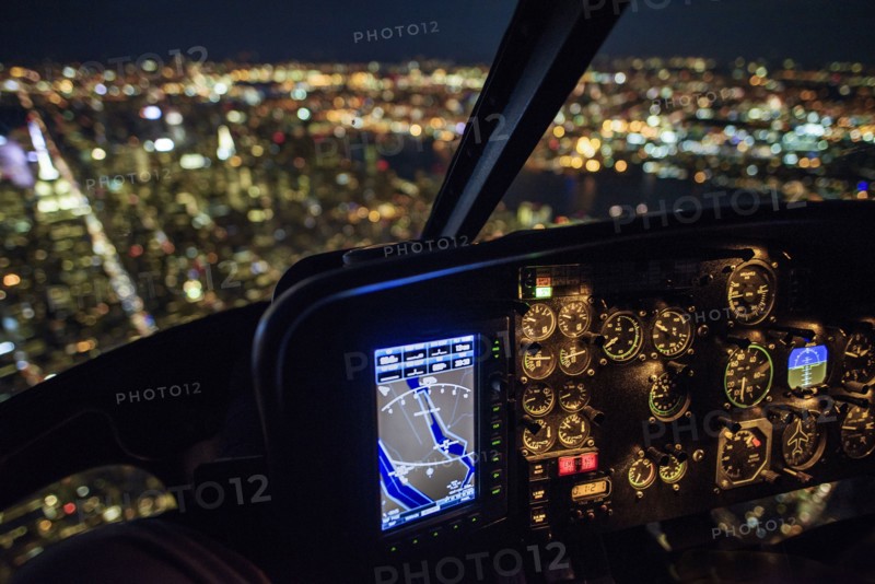 USA, New York, New York City, Illuminated skyline at night seen from helicopter cockpit.
