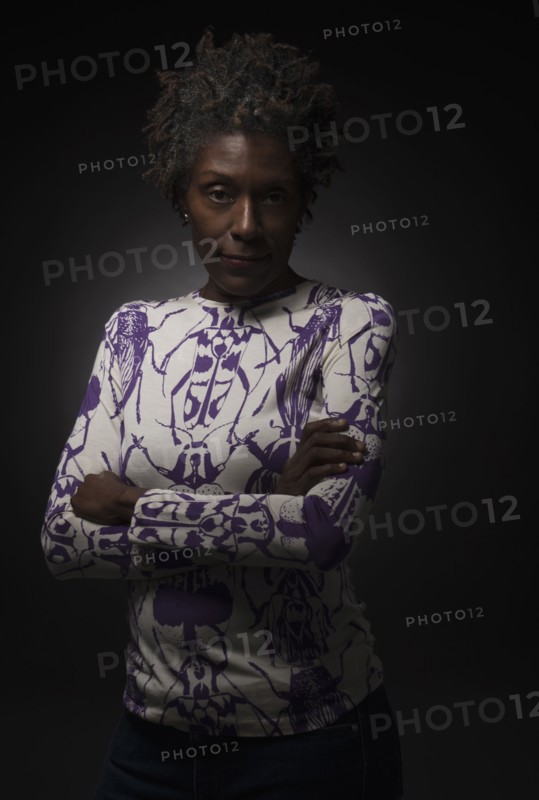 Studio shot of woman standing with arms crossed.