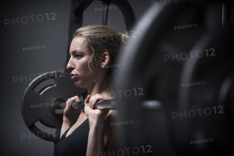 Young woman weightlifting in gym.