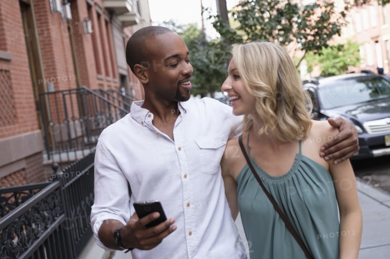Smiling couple walking in residential district.