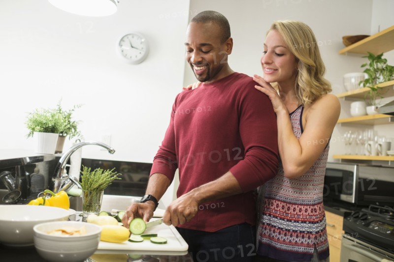 Couple preparing dinner in kitchen.