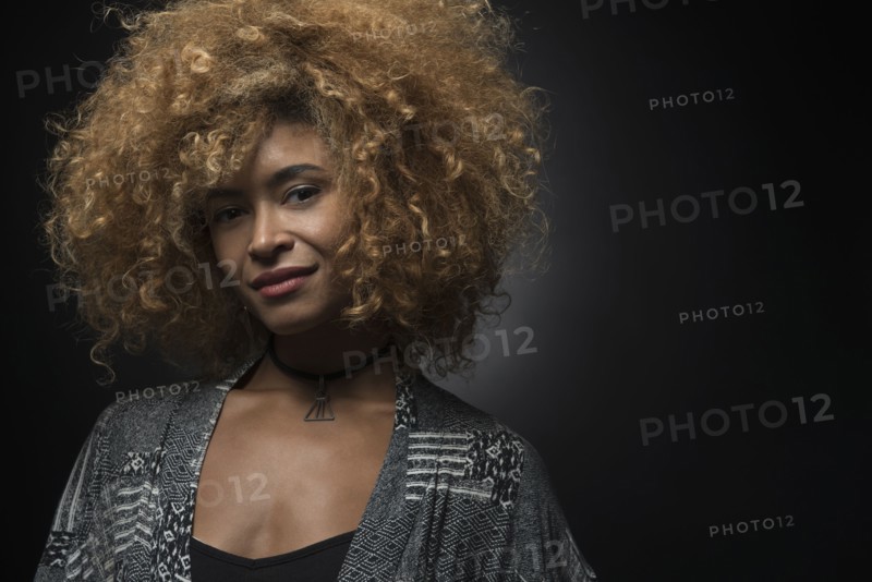 Portrait of cool blond woman on black background.