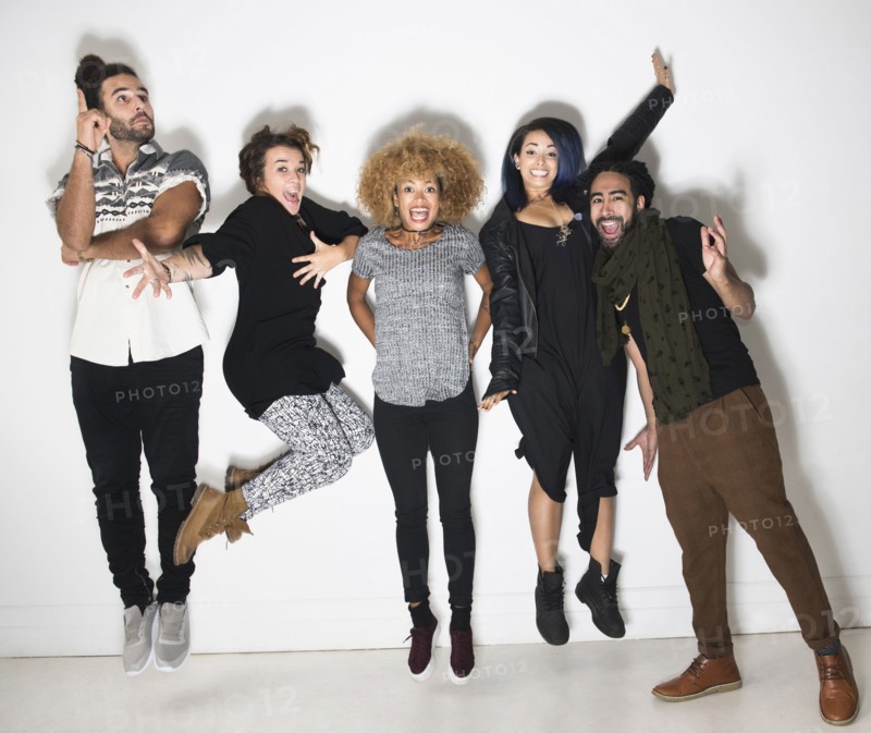 Portrait of group of happy friends against white wall.