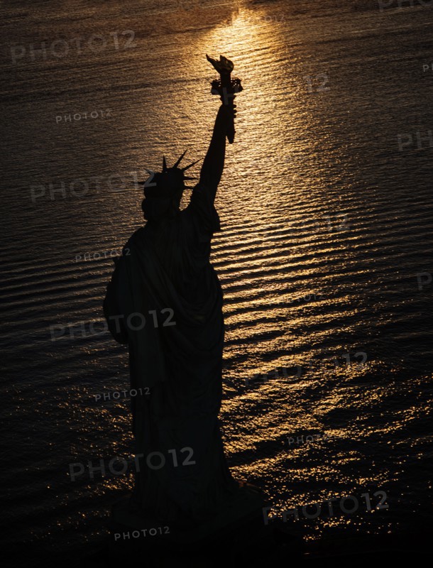 USA, New York State, New York City, Silhouette of Statue of Liberty at sunrise.