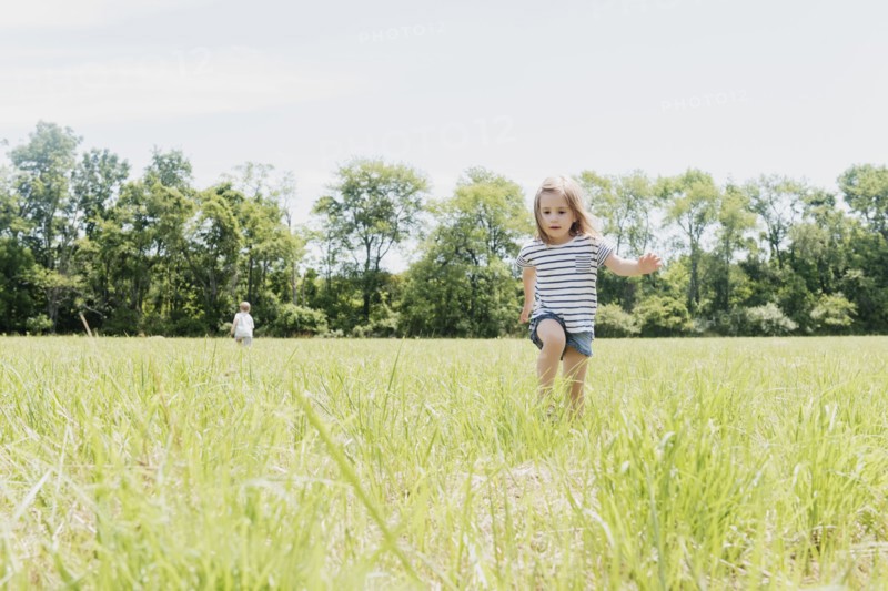 USA, Pennsylvania, Washington Crossing, Girl (2-3) and boy (4-5) walking on green field