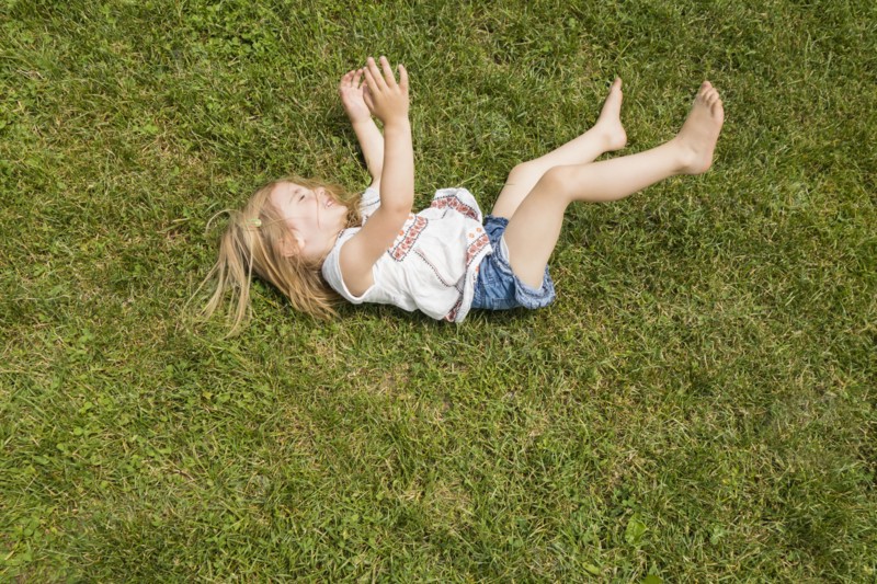 Girl (2-3) rolling on grass