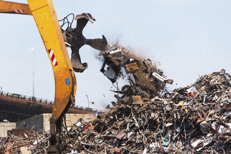 Crane and heap of scrap in junkyard