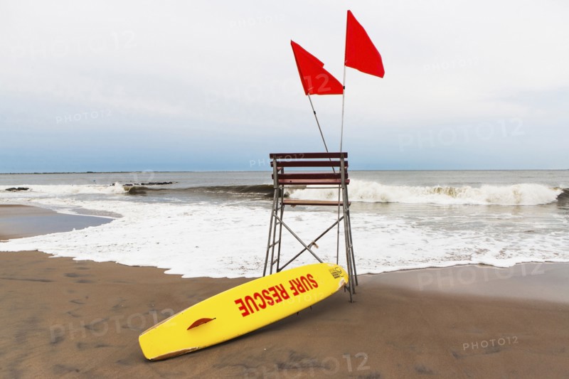 USA, New York State, New York City, Brooklyn, Yellow surfboard and empty lifeguard stand on beach