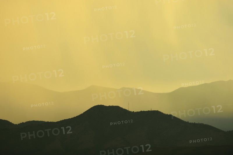 USA, Colorado, Denver, Rain against colorful sky above rocky mountains