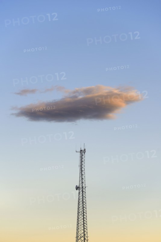 Cloud over communication tower at dusk