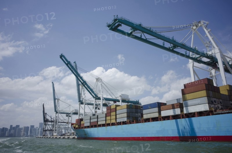 USA, Florida, Miami, Container ship with cranes and city skyline in background