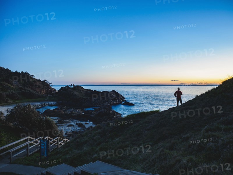 Australia, New South Wales, Port Macquarie, Silhouette of man looking at sea at sunrise
