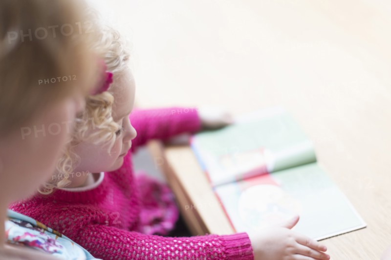 Mother and daughter (4-5) reading book