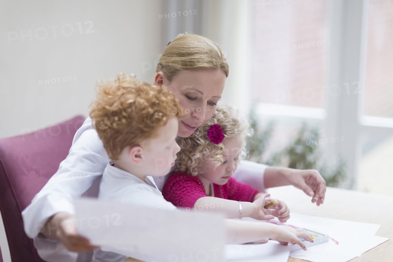 Mother looking at drawings with son (8-9) and daughter (4-5)