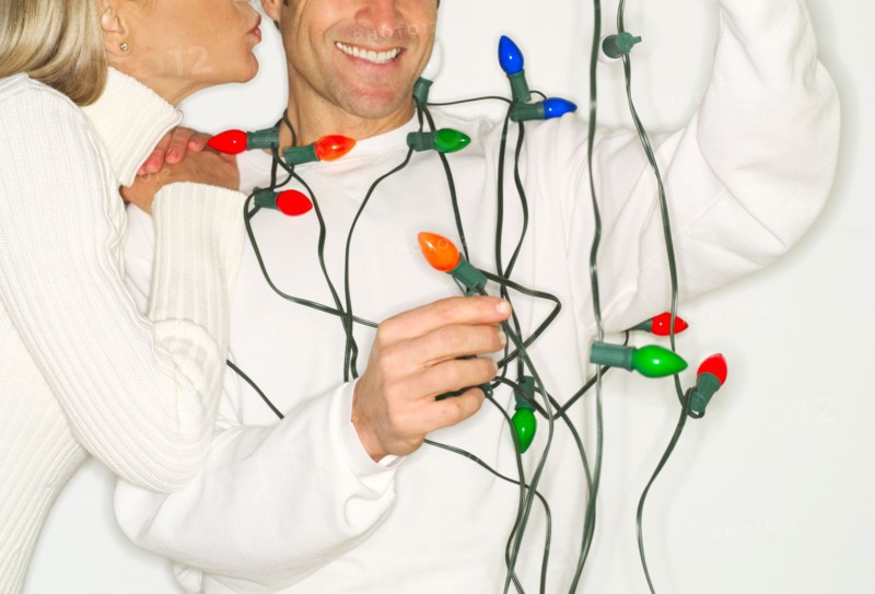 Mature couple wrapped in christmas lights.