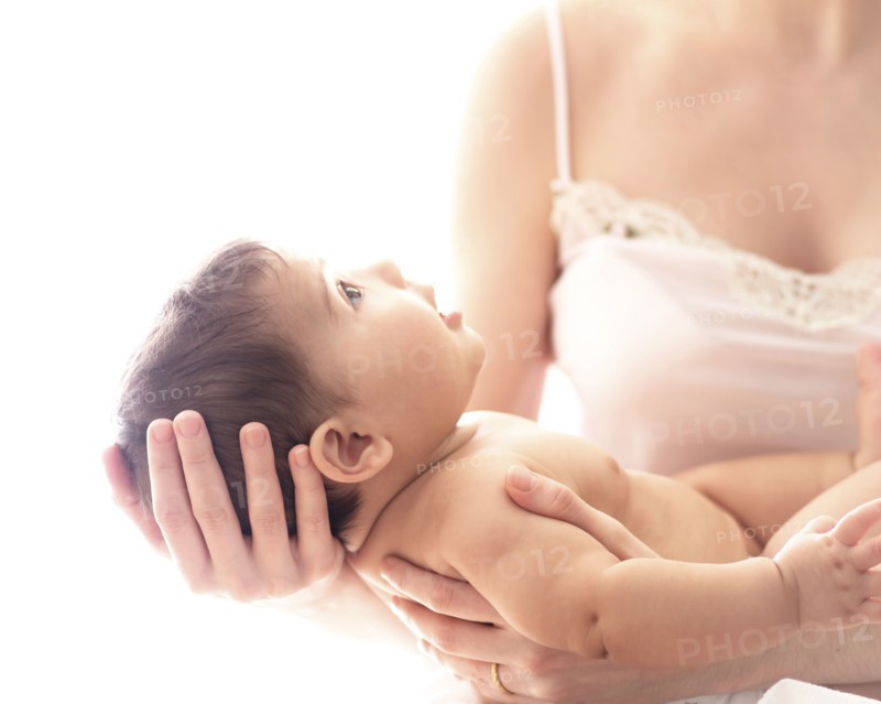 Baby girl (6-11 months) held by mid-adult woman.
