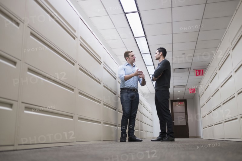 Young men talking to each other in corridor.