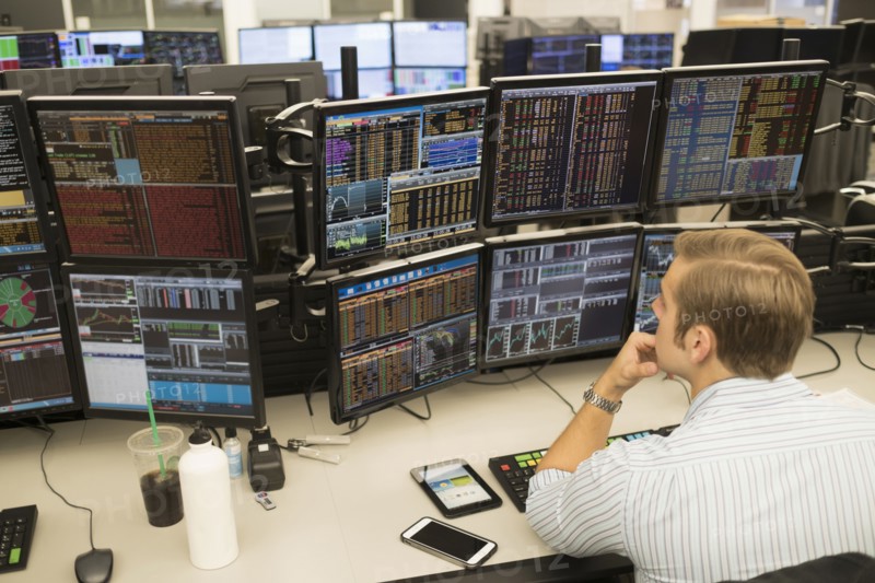 Young trader analyzing computer data.