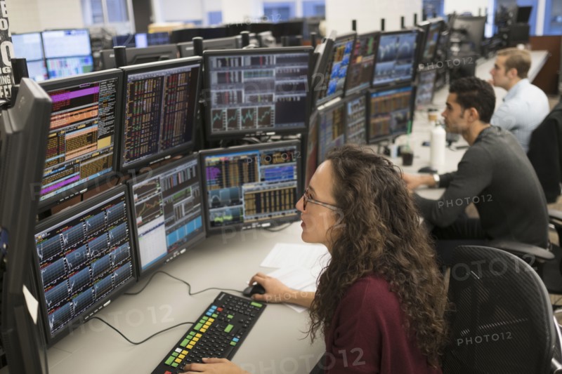 Young traders analyzing computer data.