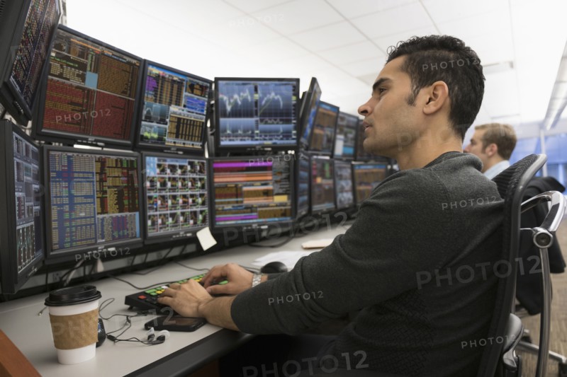 Young traders analyzing computer data.