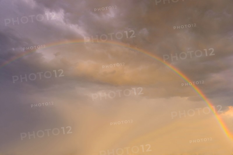 Rainbow against clouds in sunlight.