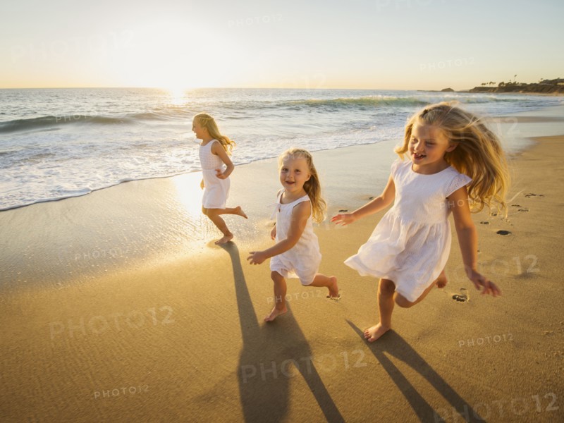 Girls (4-5, 6-7, 8-9) running on beach