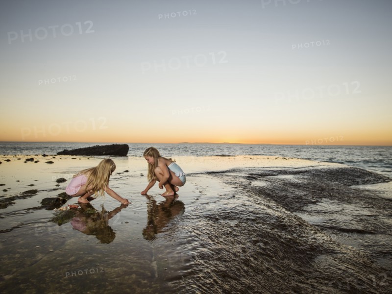 Girls (6-7,8-9) playing on beach