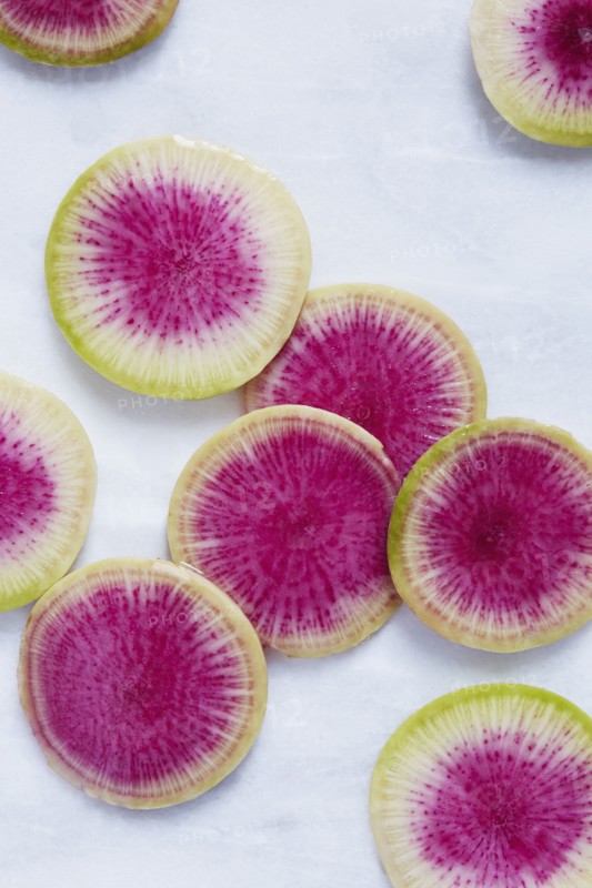 Slices of radish on white surface