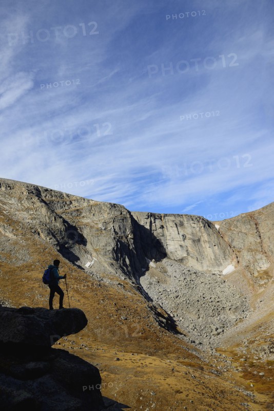USA, Colorado, Silhouette of hiker on rock ledge along Chicago Lakes Trail in Mount Evans Wilderness Area