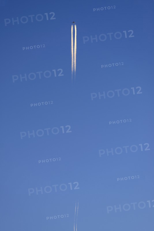 Low angle view of commercial airplane flying against blue sky