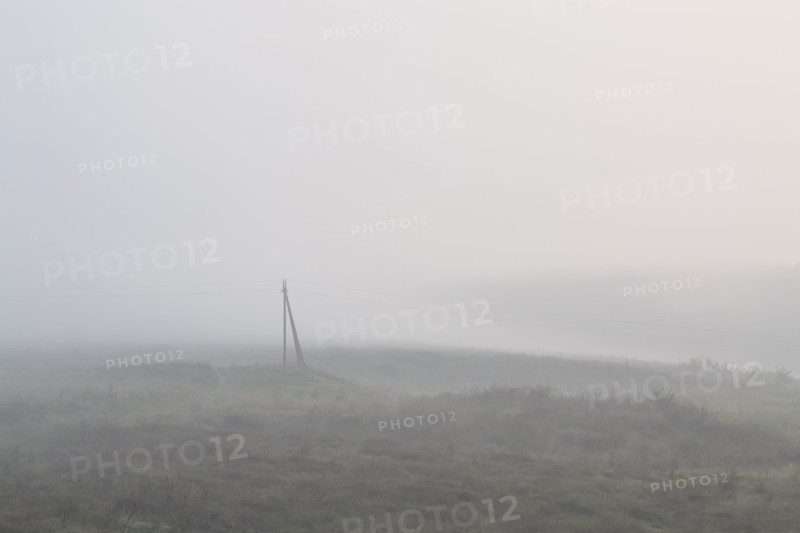 Ukraine, Dnepropetrovsk region, Novomoskovsk district, Electricity pylon standing in foggy field