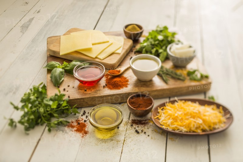 Cheese, oils and herbs on table