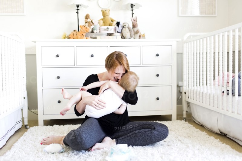 Mother holding son (12-17 months)  in nursery