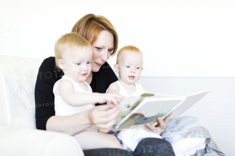 Mother and sons (12-17 months) reading picture book