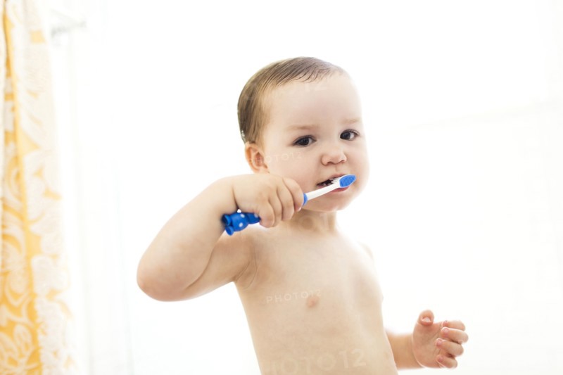 Shirtless boy (4-5)  brushing teeth
