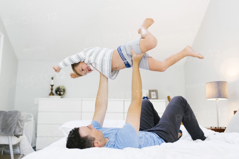 Father and son (4-5) playing in bedroom