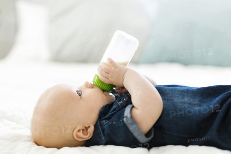 Side view of baby boy ( 12-17 months) drinking milk from bottle