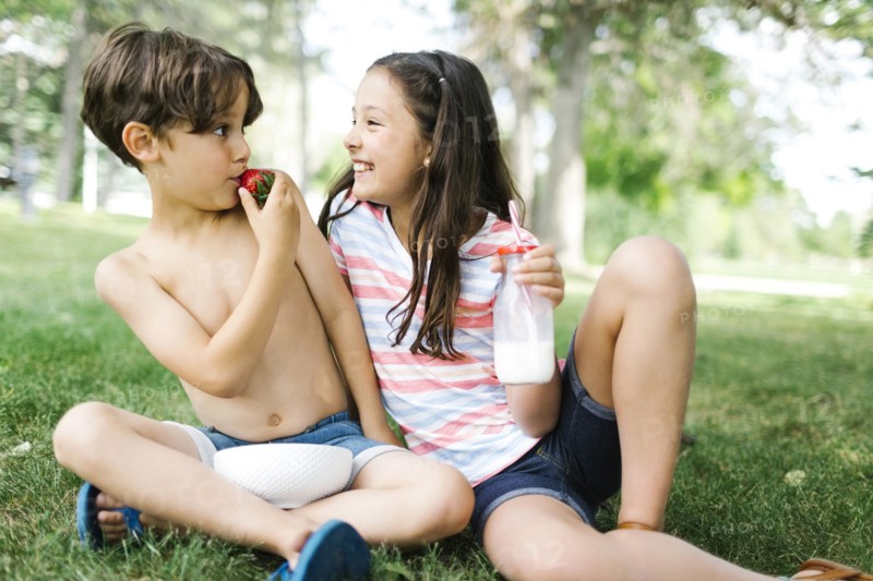 Portrait of sister ( 10-11 ) and brother (6-7 ) having fun on picnic