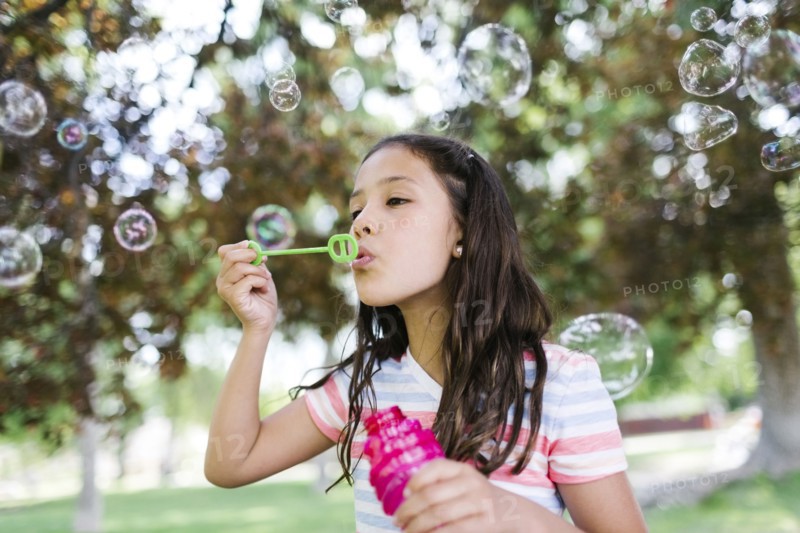 Portrait of girl ( 10-11 )  blowing soap bubbles