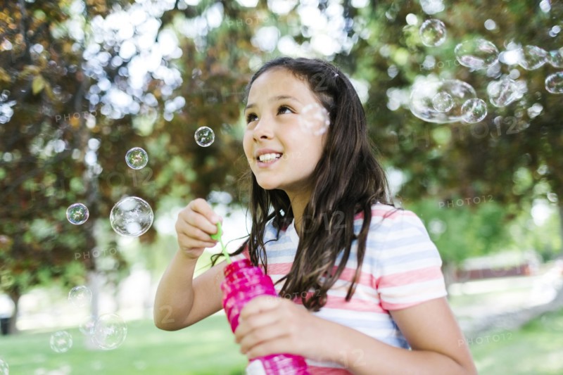 Portrait of girl ( 10-11 )  blowing soap bubbles