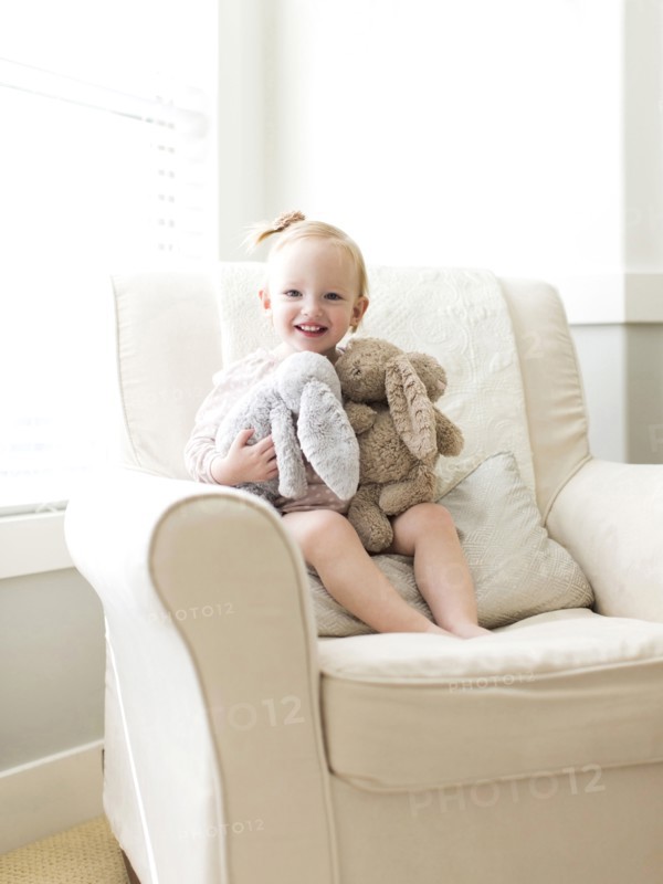 Portrait of girl ( 12-17 months ) holding stuffed toys